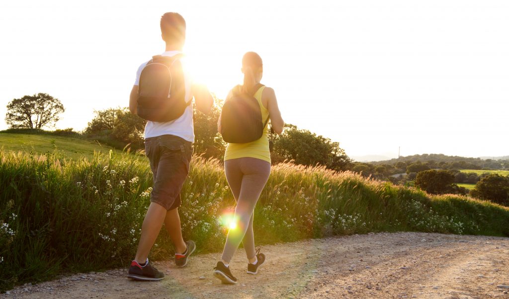 Marche bien-être couple heureux en séance de marche dans la nature